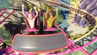 Planet Coaster 2 trailer screenshot showing characters riding a spinning roller coaster with hands in the air