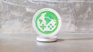 A photo of an award on a table. The award is circular and stood up on a circular base. In the middle is what looks like a globe but actually it's a deconstructed controller that looks like a globe. Around it is green and blue, and the material looks to be stone of some kind. It's very pretty actually.